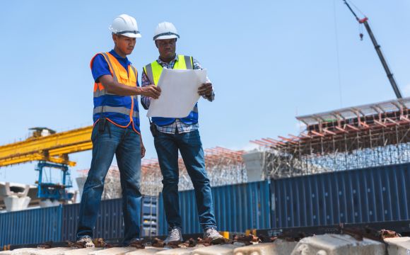 Engineers reviewing blueprints on site